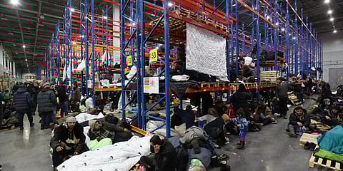 Migrants rest in a logistics center at the checkpoint 'Kuznitsa' at the Belarus-Poland border near Grodno. (Photo| AP)