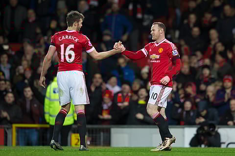 Manchester United's Wayne Rooney, right, shakes hands with teammate Michael Carrick after scoring during the English Premier League soccer match between Manchester United and Stoke at Old Trafford Sta