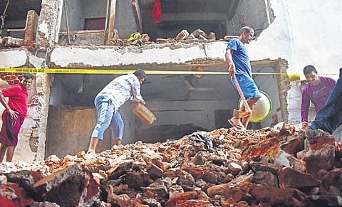 Workers clear the debris after a gas cylinder explosion damaged several parts of a building in Nanakramguda. (Photo| S Senbagapandiyan, EPS)