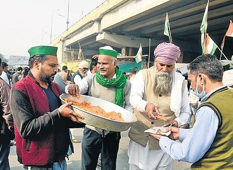 Farmers at Singhu border distribute sweets after PM Narendra Modi announced repealing of the three farm laws. (Photo | Parveen Negi, EPS)