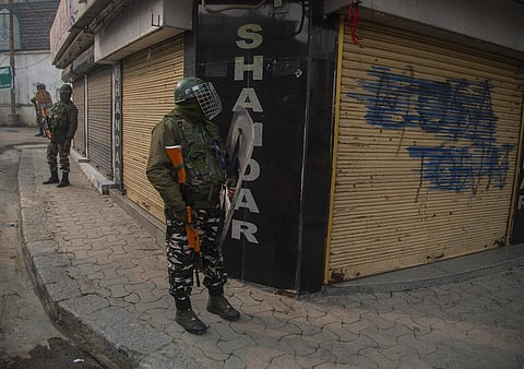 Indian paramilitary soldiers stand guard outside closed shops in Srinagar. (Photo | AP)