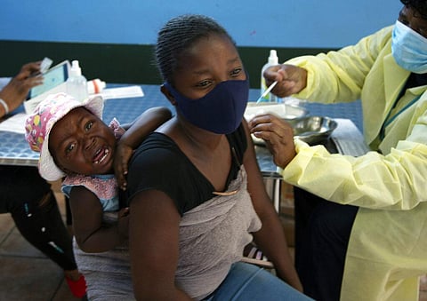 A baby cries as her mother receives her Pfizer vaccine against COVID-19, in Diepsloot Township near Johannesburg (Photo |AP)