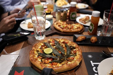 A pizza topped with a cannabis leaf is served to the customers at a restaurant in Bangkok, Thailand. (Photo | AP)