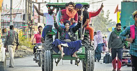 Farmers on tractor in celebratory mood at Singhu border in New Delhi. (Photo | PTI)