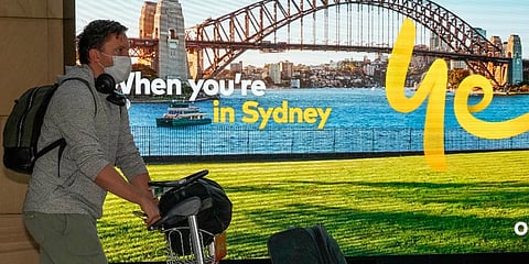 A passenger arrives on an early morning flight at Sydney Airport, Monday, Nov. 29, 2021. (Photo | AP)