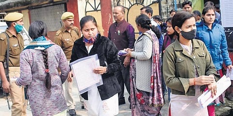 Candidates wait outside an examination centre in Gorakhpur before the announcement on cancellation was made (Photo | PTI)