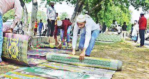 Muslim men roll up namaz mats Photo | EPS)
