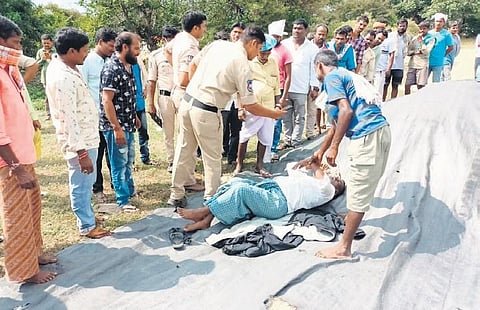 A police official clicks a picture of Beeraiah, 57, who died at an IKP centre in Lingampet mandal, Kamareddy district, while guarding his huge heap of paddy