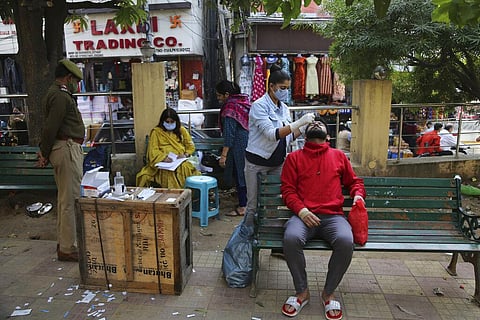 A health worker takes a nasal swab sample of a man to test for COVID-19 in Jammu. (Photo | AP)