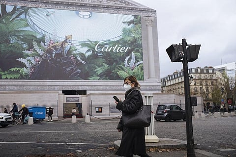 A woman wearing a face mask to protect against coronavirus walks in Paris (Photo | AP)
