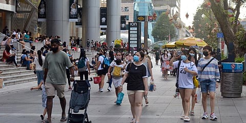 People wearing protective face masks walk along the Orchard Road shopping area in Singapore on Nov. 28, 2021. (Photo | AP)