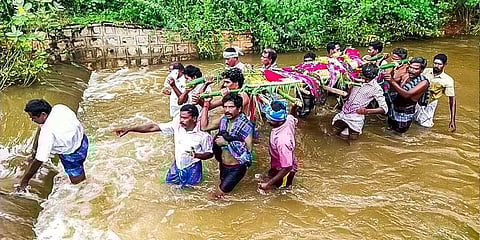 Melaveliyur village locals carrying a dead body through knee-deep floodwater in Aathuvari drain in Karur |Express
