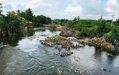 Garbage is stagnant in Marudaiyaru river in Neduvasal in Perambalur. (Photo | Express)