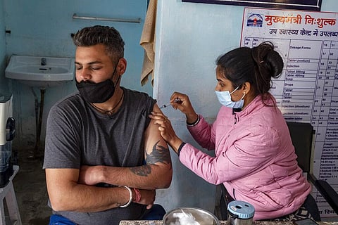 A man closes his eyes as he receives a Covishield vaccine for COVID-19 at a Primary Health Centre in Dharmsala. (Photo | AP)