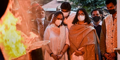 Daughters of late CoDS General Bipin Rawat and wife Madhulika look on during the cremation of their parents at Brar Square crematorium in New Delhi. (Photo| PTI)