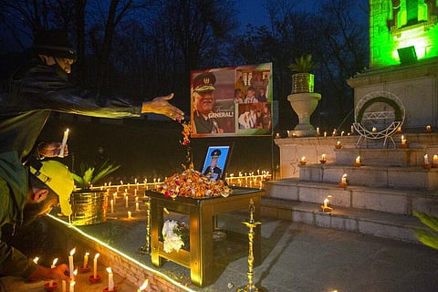 Indian army officials offer floral tributes to the portrait of military chief, Gen. Bipin Rawat at an army base in Srinagar. (Photo | AP)