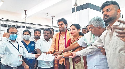JDS candidate Suraj Revanna receives a certificate from the Deputy Commissioner after his win in Hassan on Tuesday. Brother and MP Prajwal is also seen. (Photo | Express)