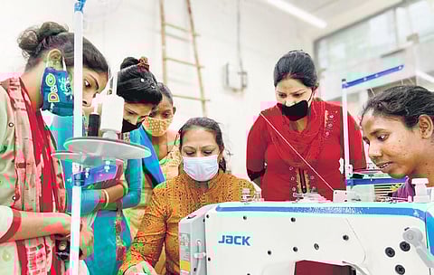 Women from Clothes Box Foundation creating blankets from fabric scraps.