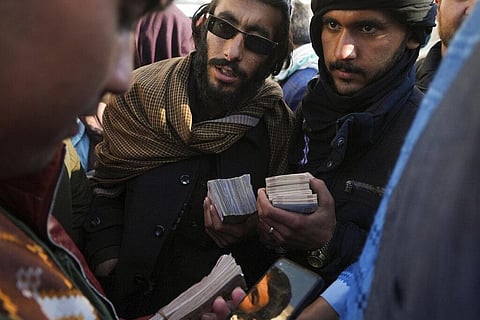Afghan money changers count money at Khorasan market in Herat, The value of Afghanistan's currency is tumbling, exacerbating severe economic crisis and deepening poverty (Photo | AP)