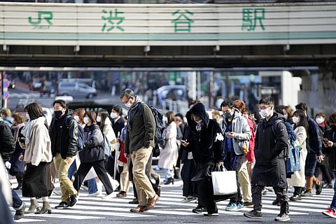 People wearing face masks walk along a pedestrian crossing at Shibuya district Friday, Dec. 17, 2021, in Tokyo. (Photo | AP)