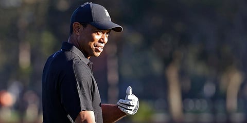 Tiger Woods smiles and gestures as he prepares to tee off during the first round of the PNC Championship golf tournament. (Photo| AP)