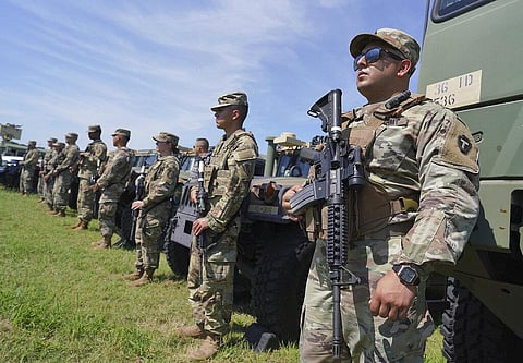 Members of the Texas Army National Guard stand by as Texas Gov. Greg Abbott and 10 other governors hold a press conference at Anzalduas Park on Oct. 6, 2021. (Photo | AP)