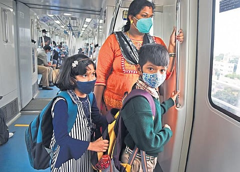 A woman and two children, wearing masks, take a less-crowded Metro in Bengaluru on Monday. (Photo | Vinod Kumar T/EPS)