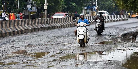 Motorists riding on the pothole-ridden Dindigul highway in Tiruchy. (Photo | MK Ashok Kumar)