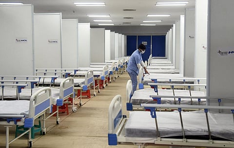 A worker prepares a bed for Covid patients in Commonwealth Games Village in view of the Omicron cases, in New Delhi. (Photo | Parveen Negi, EPS)
