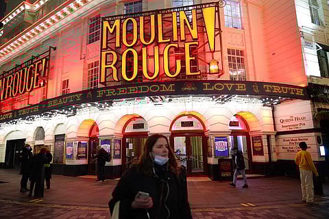 People stand near to the Piccadilly Theatre which has been forced to cancel performances of Moulin Rouge! The Musical, from Monday until Thursday Dec, 23. (Photo | AP)