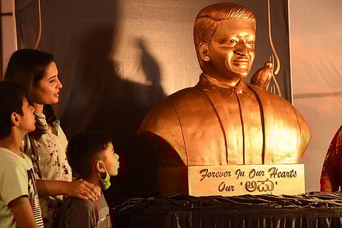 Visitors admire the bust of late actor Puneeth Rajkumar, made of chocolate cake, on display at the annual cake show in Bengaluru on Monday | Nagaraja Gadekal