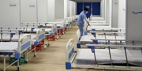A worker prepares a bed for COVID patients in Commonwealth Games Village in view of the Omicron cases, in New Delhi. (Photo | Parveen Negi, EPS)