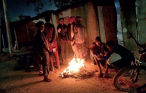 A group of people keep themselves warm near a bonfire at Rourkela. (Photo | Express)