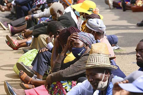 Elderly people, many without face masks or not fitted properly, sit in tightly packed lines waiting to withdraw their pensions in Harare, Zimbabwe.(Photo | AP)