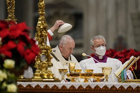 An aide removes Pope Francis' skull cap during Christmas Eve Mass, at St. Peter's Basilica, at the Vatican, Friday Dec. 24, 2021. (Photo | AP)