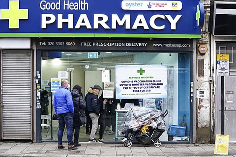People wait in line to receive a 'Jingle Jab' Covid vaccination booster injection at the Good Health Pharmacy, north London, Saturday, Dec. 25, 2021. (Photo | AP)