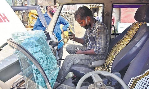 A mechanic repairing the police jeep that was destroyed by migrant workers