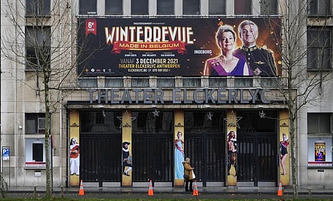 A woman stands in front of a closed theater in Antwerp, Belgium on Monday, Dec. 27, 2021. (Photo | AP)