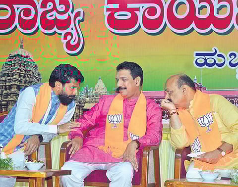Chief Minister Basavaraj Bommai speaks with BJP state chief Nalin Kumar Kateel and national general secretary C T Ravi in Hubballi on Wednesday | D Hemanth