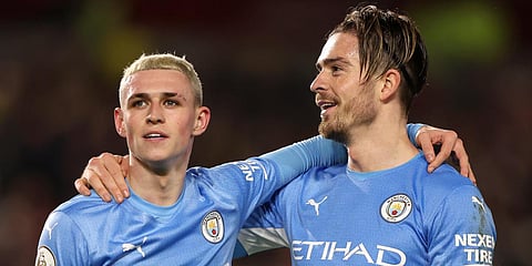 Manchester City's Phil Foden (L) and Jack Grealish embrace after a Premier League match against Brentford in London. (Photo| AP)