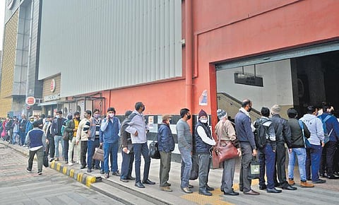 Passengers waited in long queues outside metro stations and at bus stops after the announcement of 50 per cent occupancy in all public transport. (Photo | Shekhar Yadav & PTI)