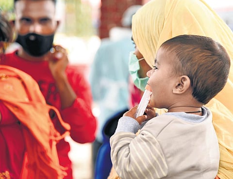 A child fiddling with RT-PCR test sample cartridge at a testing centre in Bengaluru | Nagaraja Gadekal