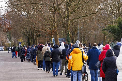 Many people wait outside a swimming pool where booster shots against Corona are given in Bad Krozingen, Germany, Friday, Dec. 3, 2021. (Photo | AP)