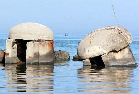 Albanian fishermen throw their net from their boat near bunkers on the beach at the Adriatic sea in the city of Durres, some 40 km from the Albanian capital Tirana, 15 August 2006. (Photo | AFP)