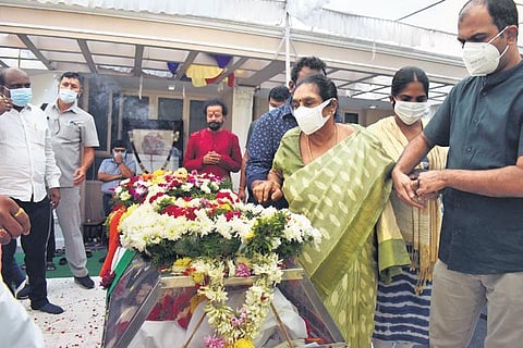 A grief-stricken Sivalakshmi stands near the mortal remains of her late husband K Rosaiah, in Hyderabad on Saturday, Dec 4, 2021. (Photo |S Senbagapandiyan)
