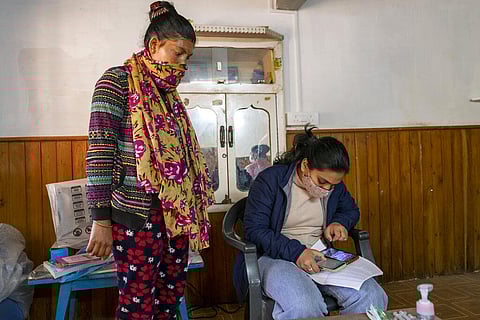 A woman registers herself to receive a Covishield vaccine for COVID-19 at a Primary Health Centre in Dharmsala. (Photo | AP)