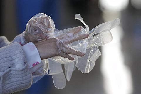 A visitor wears plastic gloves to help curb the spread of the coronavirus upon arrival at an exhibition hall in Goyang, South Korea. (Photo | AP)