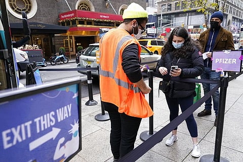A health care worker, left, checks people in at a NYC mobile vaccine clinic in Midtown Manhattan, Monday, Dec. 6, 2021. (Photo | AP)