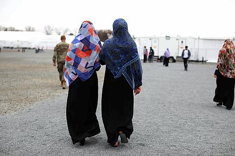 Afghan refugees women and a service member walk inside Liberty Village on Joint Base McGuire-Dix- Lakehurst in Trenton, N.J., Thursday, Dec. 2, 2021. (Photo | AP)