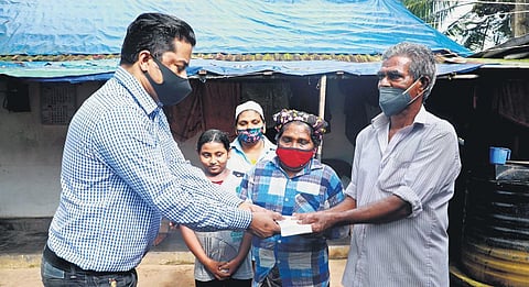 N B Swaraj, media coordinator of Lulu Group, hands overC50,000 and the receipt from the bank to Amina and Sayed Mohammad | EXPRESS